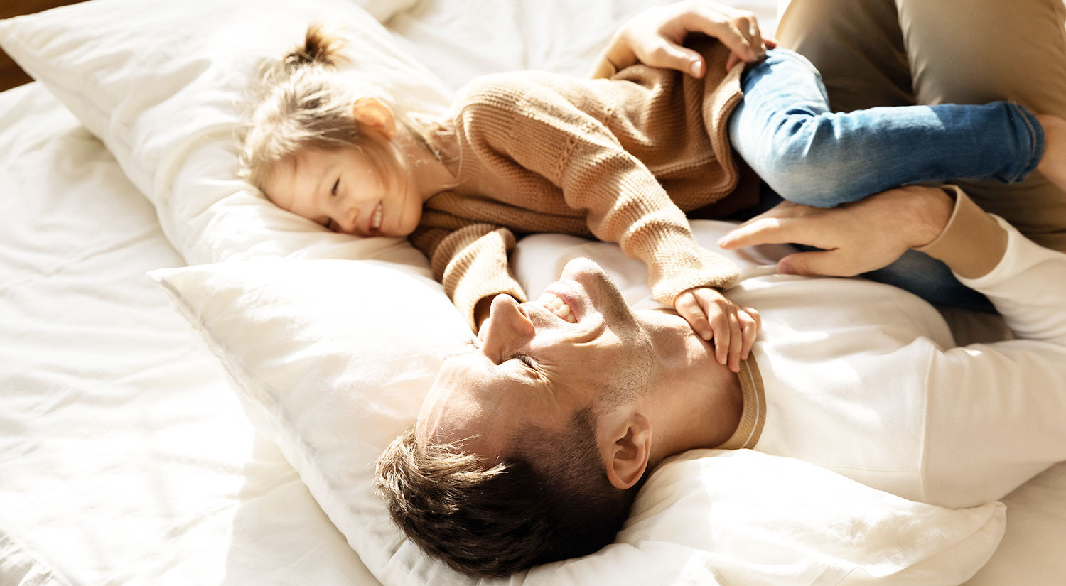 Father and daughter laughing in bed Winndom mattress