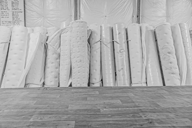 rolls of mattress covers lined up on a wall, WInndom Mattress warehouse Hopewell, Virginia, innerspring mattress, foam mattress