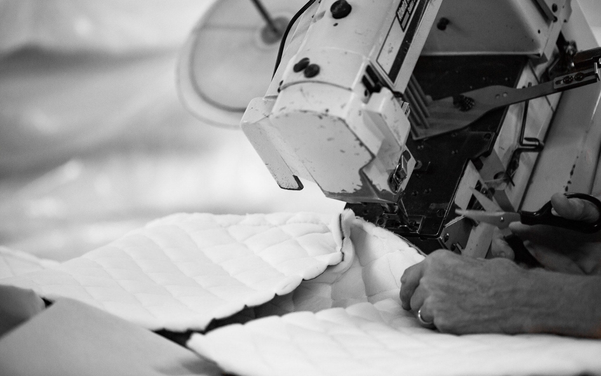 Man using sewing machine to make a mattress