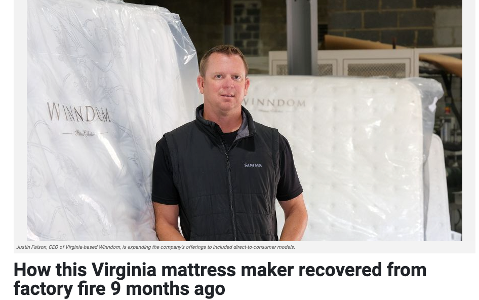 Man in a black shirt standing in front of mattresses with 'Winndom' branding.