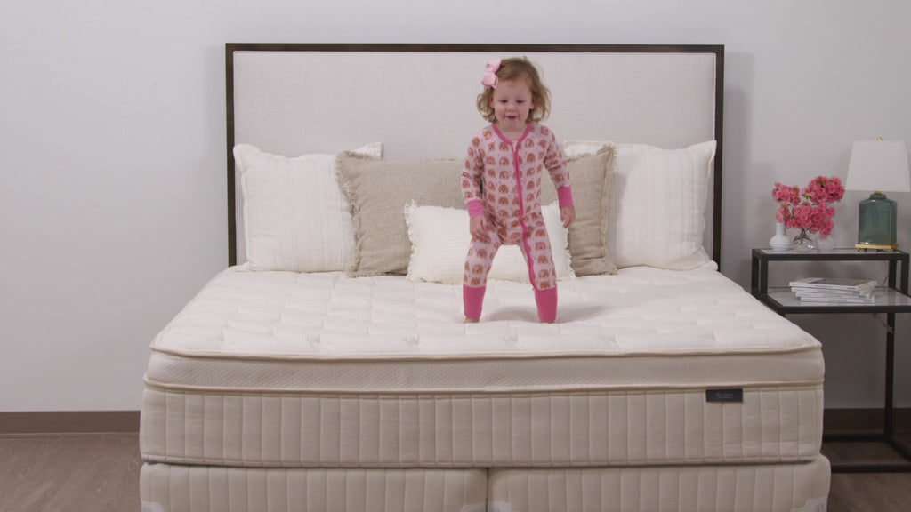 Girl jumping on Winndom mattress and puppy laying on Winndom mattress