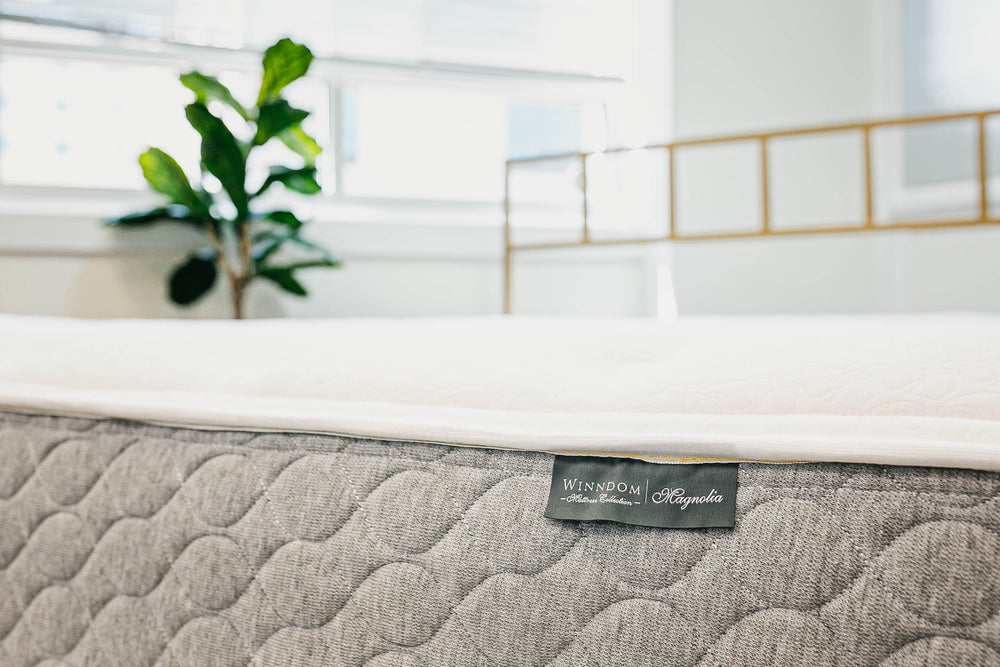 Foot of the Winndom mattress collection Magnolia mattress with tree in the background. Winndom Magnolia mattress, innerspring mattress, foam mattress American made mattress